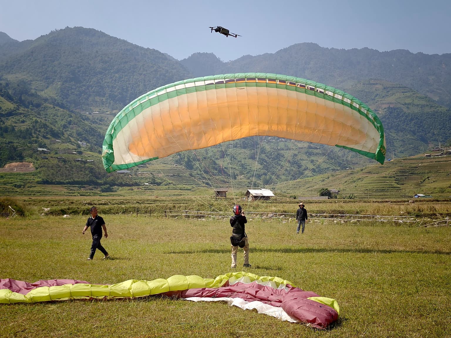 A student inflating and controlling the wing on her own; the instructor watches from a distance and steps in only when needed.