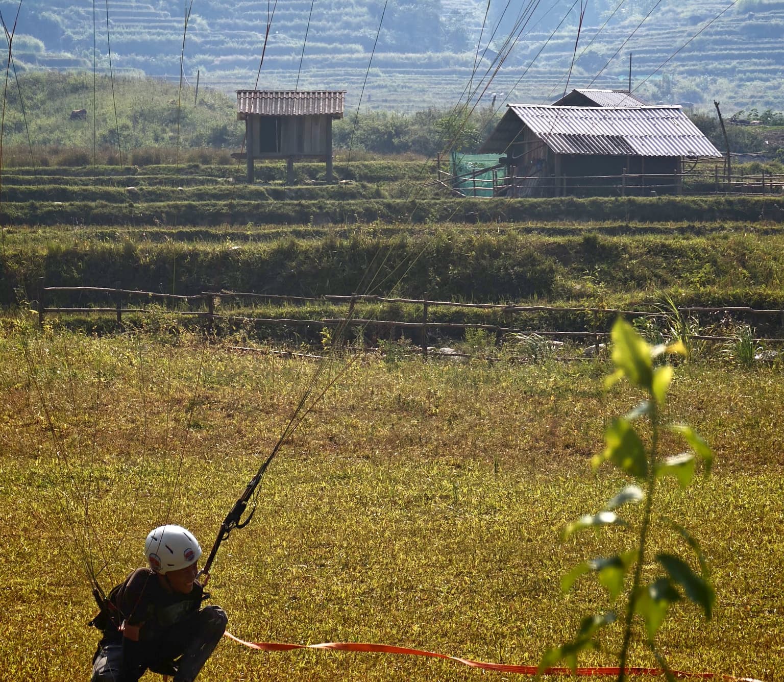 Before a tow: the tow line (red) is attached to the harness and the student holds the risers, ready to inflate.