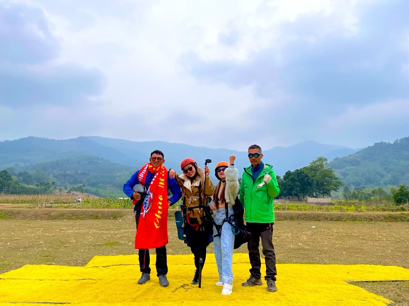Pilots and guests on the yellow target mats at the Doi Bu landing field, hills behind