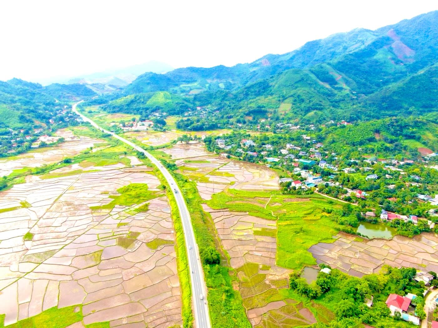 Flycam nhìn dọc đường Hoà Lạc – Hoà Bình qua thung lũng Viên Nam, bãi hạ cánh sát đường lớn và dãy núi có bãi cất cánh bên phải