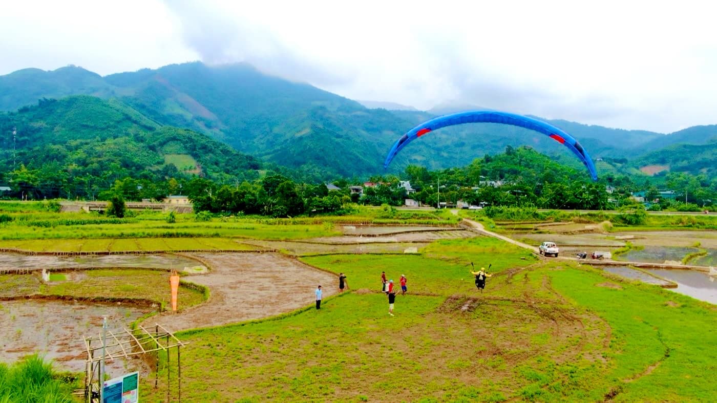 A tandem touching down on the Vien Nam landing field with windsock, beside the Hoa Lac – Hoa Binh road
